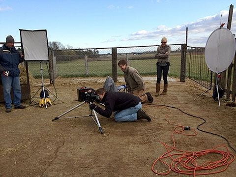 Behind the scenes action shot of professional commercial photographer on farm