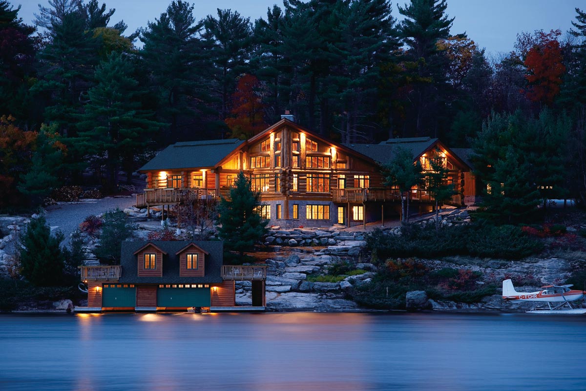 Exterior Architectural Photography of lakeshore log Muskoka cottage mansion with airplane and boathouse