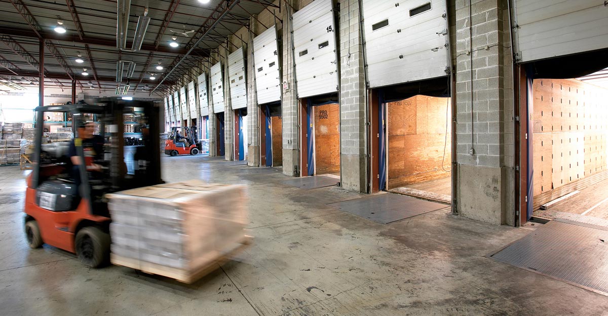 Industrial Equipment Photography of forklift loading transport trucks in warehouse