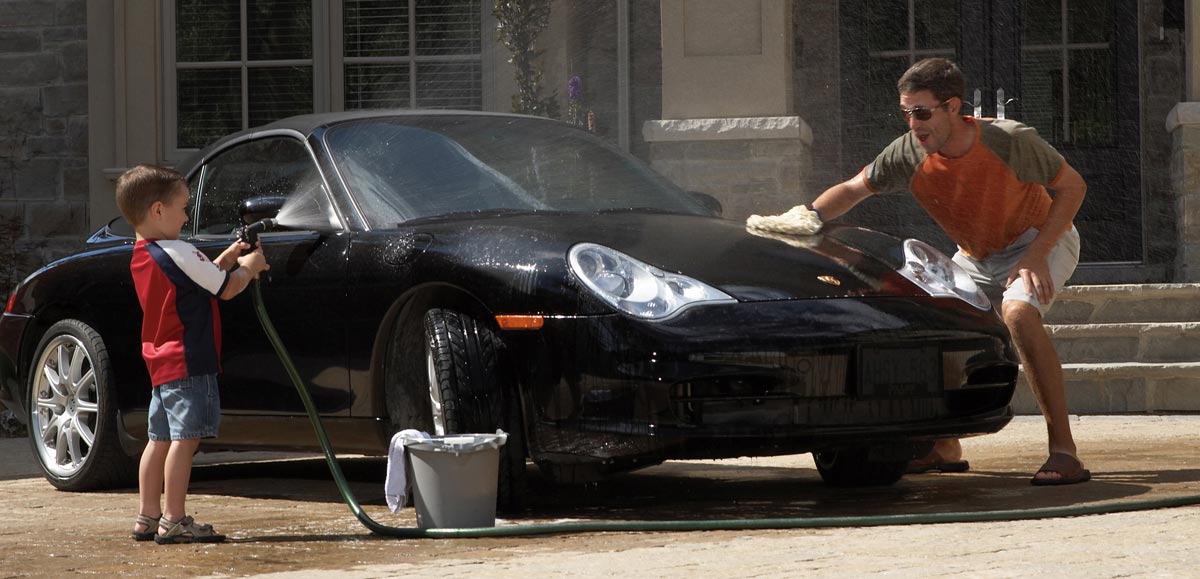 Lifestyle Family Photography of father and son washing black convertible Porsche