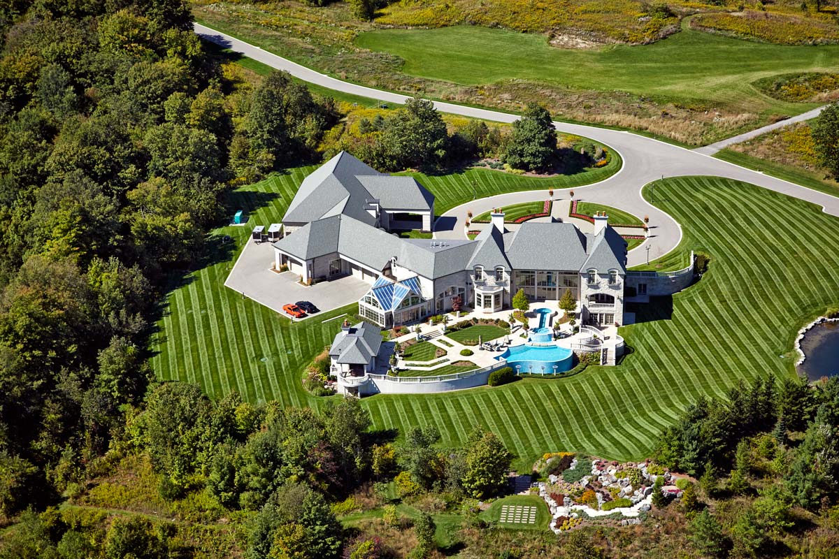 Aerial Photography of private mansion with pool and groomed lawn
