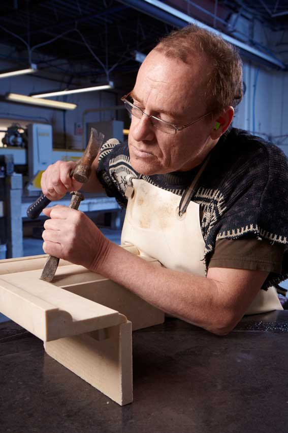 Industrial photography of worker using chisel for custom counter