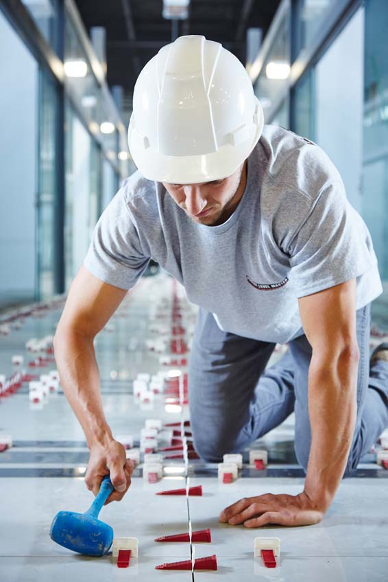 Industrial photography of worker installing glass flooring