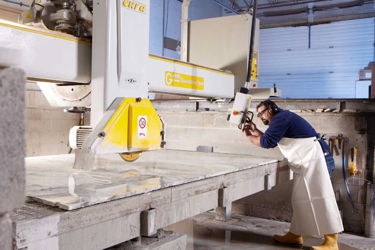 Industrial photography of worker cutting granite for counter top