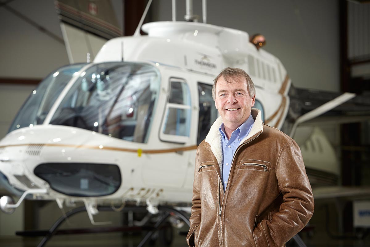 Portrait photography of pilot with helicopter in airport hanger